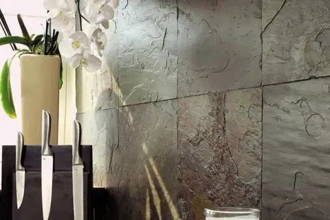 Kamienna ściana z łupków kamiennych, ozdobiona białymi orchideami i eleganckimi nożami.