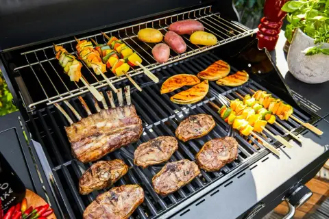 Côtelettes d'agneau, brochettes de légumes et pommes de terre en cuisson barbecue. Un festin en plein air !