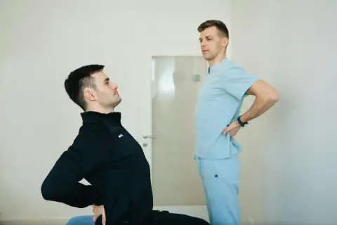 Fizjoterapeuta ocenia plecy okrągłe pacjenta.
