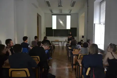 Wykład o astronomii, studenci słuchają o galaktykach.