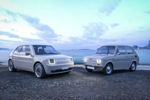 Nowy Fiat 126p obok swojego klasycznego poprzednika, na tle wodnego miasta.