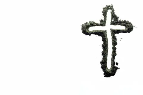 Krzyż z popiołu na białym tle. Czy kłótnia to grzech ciężki? Symbolizuje pokutę i refleksję nad własnymi czynami.