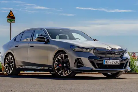Srebrne BMW 520 z czarnymi akcentami stoi na tle błękitnego nieba i morza.