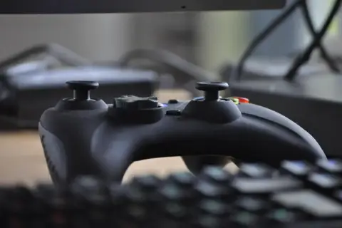 Czarny kontroler do gier na klawiaturze. Dowiedz się, jak zrobić spójność plików Steam, by cieszyć się płynną rozgrywką.