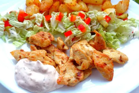 Pyszna shoarma z kurczaka z chrupiącymi ziemniaczkami, świeżą sałatką i kremowym sosem. Idealny posiłek na szybki obiad.