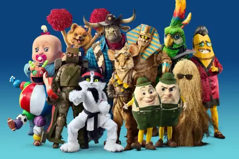 En grupp fantasifulla karaktärer, som från Masked Singer Sverige, poserar framför en blå bakgrund.
