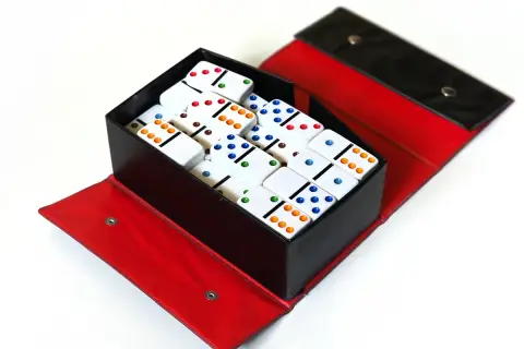 Kolorowe domino w pudełku, idealne do nauki zasad gry dla dzieci.