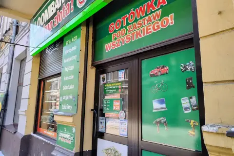 Szyld lombardu z napisem "GOTÓWKA POD ZASTAW WSZYSTKIEGO!" i grafikami przedmiotów.