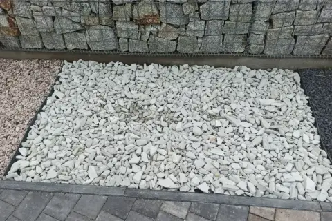 Jasny grys dolomitowy tworzy estetyczną ścieżkę obok gabionów i innych kruszyw.