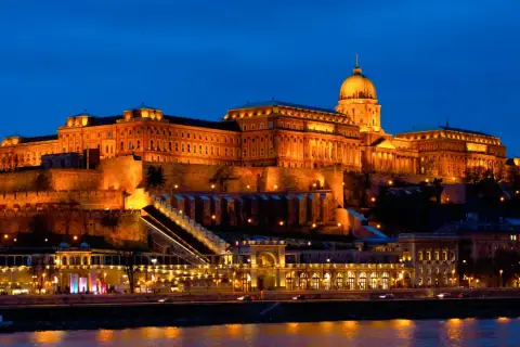 Zamek Królewski w Budapeszcie nocą, oświetlony ciepłym blaskiem. Sprawdź cennik zwiedzania!