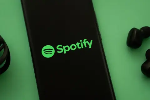 Telefon z logo Spotify i słuchawkami. Słuchaj muzyki na Spotify za darmo!