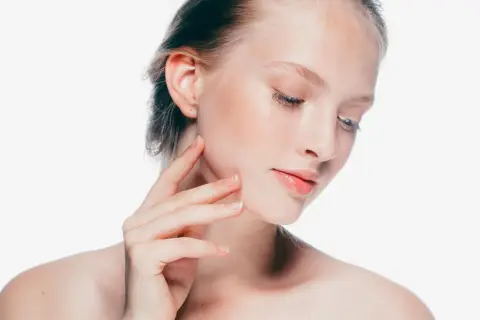 Delikatna skóra młodej kobiety, jej herla dotyka policzka, podkreślając naturalne piękno.