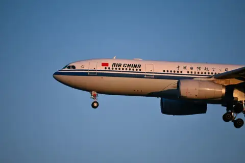 Samolot Air China z wysuniętym podwoziem, gotowy do lądowania. Wiele osób szuka pozytywnych air china opinie przed podróżą.