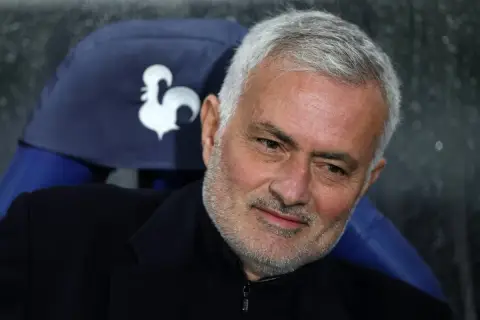 Jose Mourinho, znany trener Realu, z siwą brodą i zmęczonym spojrzeniem, siedzi na ławce.