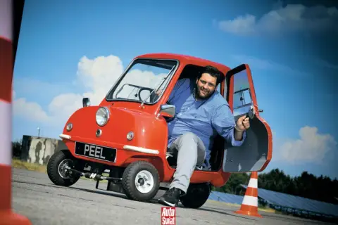 Uśmiechnięty mężczyzna w czerwonym Peel P50. Czy to najtańszy samochód świata?