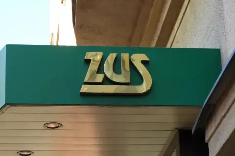 Złote logo ZUS na zielonym tle. Może to miejsce, gdzie załatwisz świadczenie urlopowe.