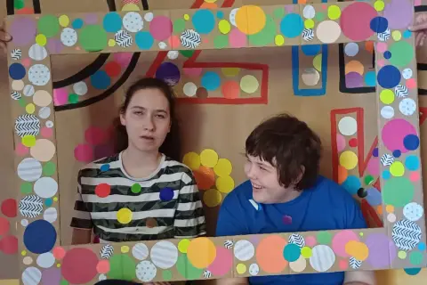 Dwie dziewczynki w ramie z kolorowych kółek.
