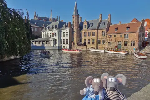 Deux peluches souris profitent d'une balade en bateau sur les canaux de Bruges, une excellente idée pour savoir que faire à Bruges.