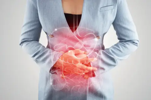 Frau hält sich den schmerzenden Bauch, rote Darstellung des Verdauungstrakts. Mögliche bauchfellentzündung symptome.