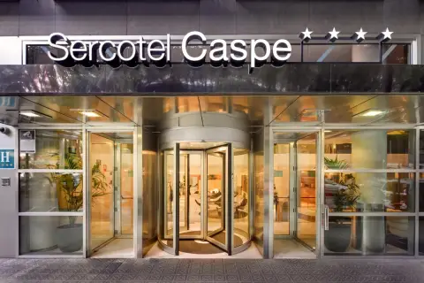 Entrada principal del Sercotel Caspe, con puerta giratoria y letrero luminoso.
