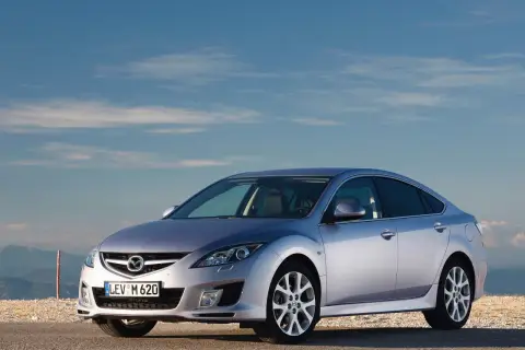 Srebrna Mazda 6 2.0 benzyna na tle błękitnego nieba i gór.