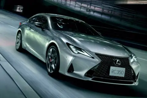 Srebrny Lexus RC 350 pędzi nocą przez tunel, jego światła przecinają mrok.