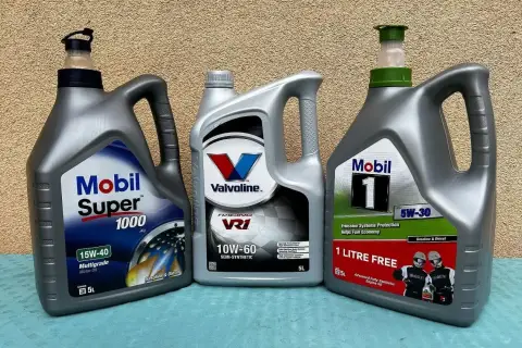 Trzy bańki oleju silnikowego: Mobil Super 1000 15W-40, Valvoline VR1 10W-60 i Mobil 1 5W-30. Test olejów silnikowych 5w30.