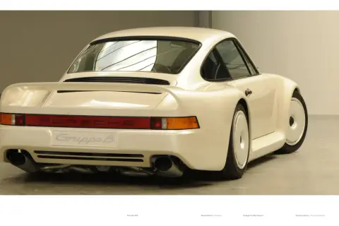 Biały Porsche 959 z napisem "Gruppe B" na tyle, prezentujący swoje charakterystyczne linie i podwójne końcówki wydechu.