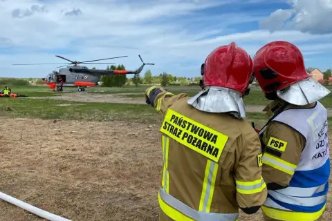 Strażacy w akcji przy śmigłowcu. Zastanawiasz się, ile zarabia strażak po szkole oficerskiej?