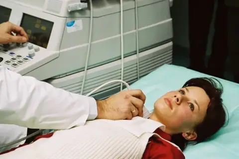 Lekarz wykonuje USG szyi pacjentce. Dostęp do opieki medycznej, w tym badań, jest ważny, nawet gdy szukasz pracy i masz ubezpieczenie zdrowotne dla bezrobotnych.