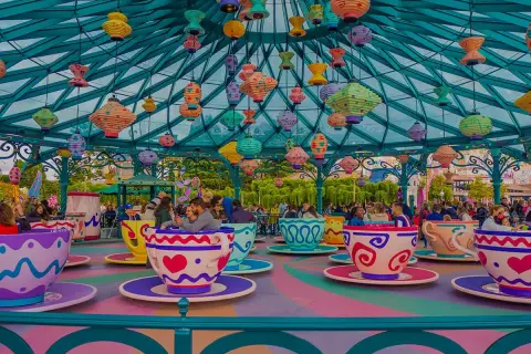 Kolorowa karuzela w kształcie filiżanek w Disneylandzie w Europie, z mnóstwem wiszących lampionów.
