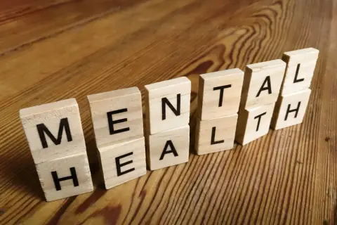 Drewniane klocki z literami tworzą napis "MENTAL HEALTH". To przypomnienie, jak panować nad emocjami i dbać o siebie.