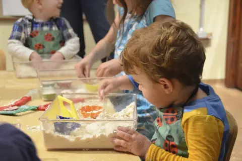 Dzieci bawią się masą sensoryczną, tworząc własne światy. Świetne zajęcia sensoryczne pomysły na kreatywną zabawę.