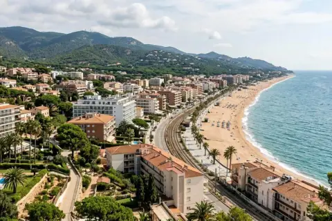 Vista aérea de una ciudad costera con edificios, playa y mar azul. Las **zenhotels opiniones** de este lugar sugieren una estancia relajante.