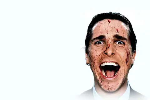 Christian Bale z "American Psycho" obsada, z krwią na twarzy, krzyczy.