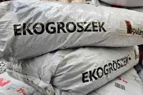 Stos worków z napisem "EKOGROSZEK". W obliczu zakazu palenia ekogroszkiem, te worki mogą stać się symbolem zmian.