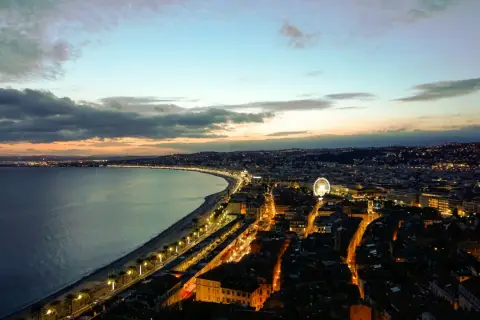Widok na wybrzeże Nicei o zmierzchu, z oświetlonym miastem i morzem. Nawet w styczniu, Nicea oferuje piękną pogodę i widoki.