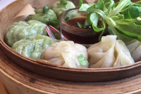 Parowóz z dim sum: zielone i białe pierożki z sosem i sałatką.