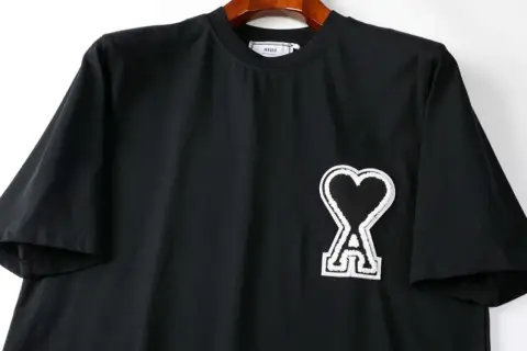 Czarna koszulka z logo serca i literą "A" od firmy AMI Paris.