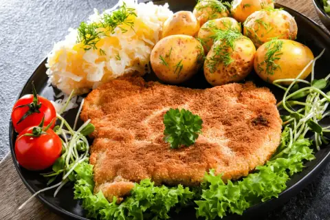 Złocisty kotlet słoneczny, podany z ziemniaczkami, mizerią i pomidorkami. Pyszny obiad!
