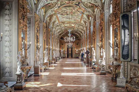 Le **Palazzo Doria Pamphilj**, un corridor orné de statues et de fresques, baigné de lumière.