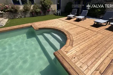 Terrasse en bois autour d'une piscine. La différence bois classe 3 et 4 est visible dans la teinte et la résistance.