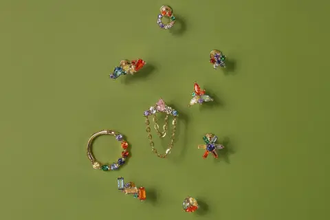 Kolorowe, błyszczące ozdoby do uszu, w tym kolczyki i kółko, prezentują różnorodność stylów piercingu.
