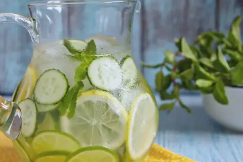 Dzbanek orzeźwiającej, sassy water z cytryną, limonką, ogórkiem i miętą, pełen lodu.