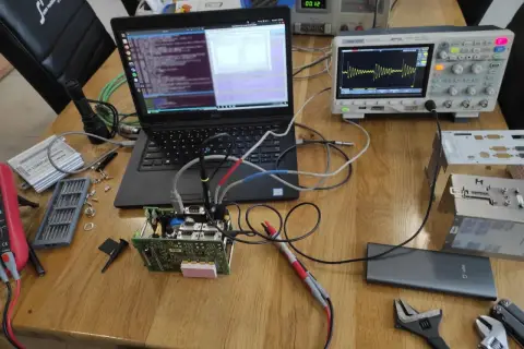 Testowanie układu elektronicznego z użyciem oscyloskopu i laptopa. Widoczne są różne etapy pracy, od podłączenia po analizę sygnału, co pokazuje kolejność faz testowania.