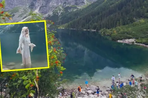 W kadrze widać Morskie Oko, a w jego głębinach postać w białej sukni. Wokół jeziora spacerują turyści.