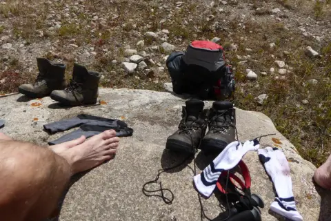 Buty trekkingowe i skarpety na skale. Czas na przewietrzenie stóp i zastanowienie, jak pozbyć się zapachu z butów po długiej wędrówce.