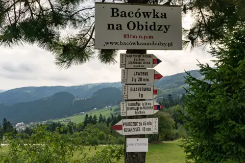 Znaki szlaków turystycznych w górach, wskazujące drogę do Radziejowej i innych miejsc.