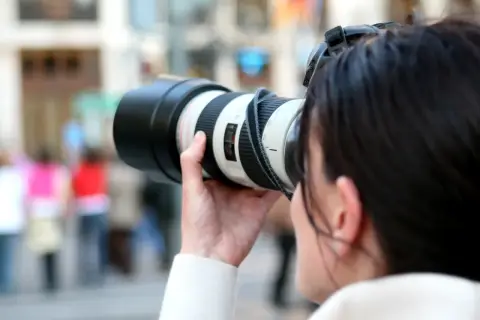 Kobieta z aparatem, gotowa do uchwycenia chwili. Inspiracja dla każdego bloga o fotografii.