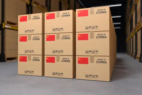 Paczki z Chin piętrzą się w magazynie, gotowe do wysyłki. Każde pudełko z chińską flagą i napisem "Made in China" czeka na swoją podróż.